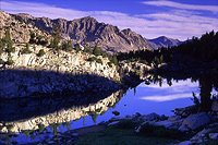 Morning shadows creeping across mountains and a lake in Sixty Lakes Basin in the High Sierra