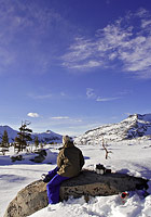Skier melting snow for water at Lake Aloha in the High Sierra, Desolation Wilderness, El Dorado National Forest