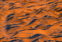sand formations along the beach lit by the setting sun
