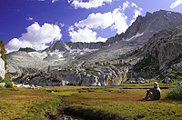 Backpacker taking a rest to enjoy the view in a high sierra meadow
