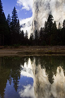 Reflection of the lower half of El Capitan in the Merced River with clouds breaking after a fall storm