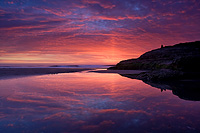 sunset reflecting in water on a beach